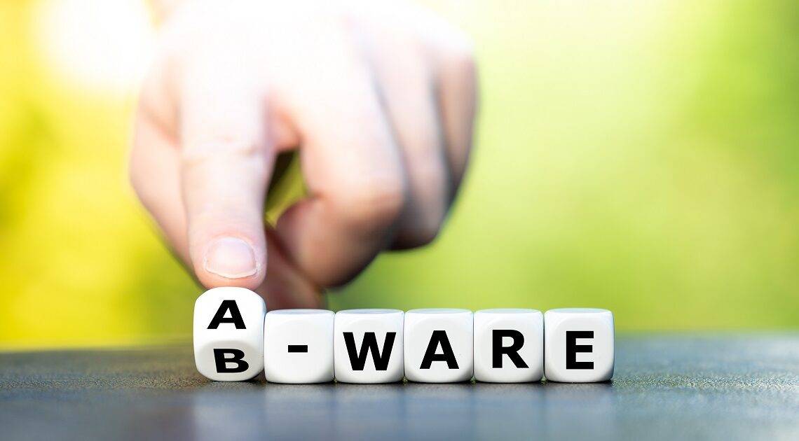 Hand dreht Würfel und ändert den Ausdruck "B-Ware" in "A-Ware".